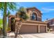 Two-story home with a three-car garage, desert landscaping and a stucco exterior with an arched window at 3055 N Red Mountain -- # 98, Mesa, AZ 85207