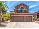 Exterior of a two-story home featuring a three-car garage, tile roof and desert landscaping at 3055 N Red Mountain -- # 98, Mesa, AZ 85207