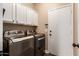 Convenient laundry room with side by side washer and dryer and additional cabinet storage at 3055 N Red Mountain -- # 98, Mesa, AZ 85207