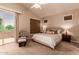 Bright main bedroom boasts a ceiling fan, a balcony with desert views, and comfortable seating at 3055 N Red Mountain -- # 98, Mesa, AZ 85207