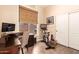 Office space with hardwood floors, dark wood desk, blinds, workout bike, and storage at 3055 N Red Mountain -- # 98, Mesa, AZ 85207