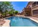 Backyard oasis with a sparkling pool, lush landscaping, and covered patio space at 3055 N Red Mountain -- # 98, Mesa, AZ 85207