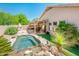 Landscaped backyard features a private pool, an outdoor kitchen area, an outdoor fireplace and artificial grass at 30844 N 41St Pl, Cave Creek, AZ 85331