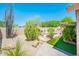 Professionally landscaped backyard featuring a cozy fireplace, desert plants, gravel, and artificial turf at 30844 N 41St Pl, Cave Creek, AZ 85331