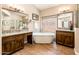 Well-lit bathroom featuring a freestanding tub, dual vanities, and tile floors at 30844 N 41St Pl, Cave Creek, AZ 85331