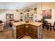 Kitchen island with granite counters, stone accents, and wood cabinetry adjacent to Gathering room at 30844 N 41St Pl, Cave Creek, AZ 85331