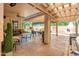 Covered patio featuring stone flooring, comfortable seating, a built-in fireplace, and views of the landscaped yard at 30844 N 41St Pl, Cave Creek, AZ 85331