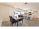 Open-concept dining area adjacent to the kitchen, featuring a rustic table and modern pendant lighting at 3118 S Los Altos Dr, Mesa, AZ 85202