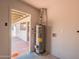 Utility room with an efficient hot water heater and access to covered patio at 3118 S Los Altos Dr, Mesa, AZ 85202