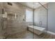 En suite bathroom featuring an oversized glass shower, soaking tub, and modern tile at 3422 E Strawberry Dr, Gilbert, AZ 85298
