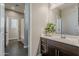 Well-lit bathroom with dark wood cabinets, ample counter space, and a view into the adjacent shower area at 3422 E Strawberry Dr, Gilbert, AZ 85298