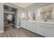 En suite bathroom featuring dual sinks, modern fixtures, decorative mirrors, and storage at 3422 E Strawberry Dr, Gilbert, AZ 85298