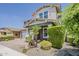 Inviting two-story home showcases a brick driveway, a two-car garage, and a front yard adorned with lush greenery and palm trees at 3422 E Strawberry Dr, Gilbert, AZ 85298