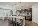 Kitchen with a central island, modern dark cabinets, and stainless steel appliances, bathed in natural light from a window at 3422 E Strawberry Dr, Gilbert, AZ 85298