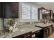 Modern kitchen featuring granite countertops, stylish backsplash, and dark wood cabinetry at 3422 E Strawberry Dr, Gilbert, AZ 85298