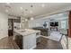 Open kitchen with dark cabinets, stainless appliances, flowing into the living area, creating a welcoming living space at 3422 E Strawberry Dr, Gilbert, AZ 85298