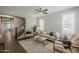 Comfortable living room boasts wood-look floors, neutral furniture, plantation shutters, and easy access to staircase at 3422 E Strawberry Dr, Gilbert, AZ 85298