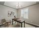 Bright office space featuring a wood desk, plantation shutters, chandelier lighting, and neutral paint at 3422 E Strawberry Dr, Gilbert, AZ 85298