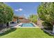 Inviting backyard pool with a meticulously landscaped lawn and shaded seating area at 3422 E Strawberry Dr, Gilbert, AZ 85298