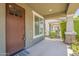 Inviting front porch with a dark wood door, neutral tones, and a glimpse of the landscaped yard and walkway at 3422 E Strawberry Dr, Gilbert, AZ 85298