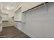 Bright walk-in closet boasts ample storage with custom shelving and wooden rods, complemented by stylish vinyl flooring at 3422 E Strawberry Dr, Gilbert, AZ 85298