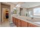 Bathroom featuring double vanity with a large mirror, soaking tub, and walk-in closet at 3458 E Ivanhoe St, Gilbert, AZ 85295