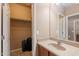 Bathroom with a single sink vanity and large mirror; walk in closet adjacent at 3458 E Ivanhoe St, Gilbert, AZ 85295