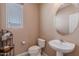 Bathroom featuring a pedestal sink, toilet, window with blinds, and decorative shelving at 3458 E Ivanhoe St, Gilbert, AZ 85295