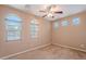 A spacious carpeted bedroom features large windows, a ceiling fan, and neutral paint at 3458 E Ivanhoe St, Gilbert, AZ 85295