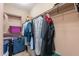 Walk-in closet with clothing and storage containers on shelving and hanging rods at 3458 E Ivanhoe St, Gilbert, AZ 85295