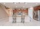 Well-lit kitchen with wood cabinets, granite countertops, tile flooring, stainless steel appliances, and a large island at 3458 E Ivanhoe St, Gilbert, AZ 85295