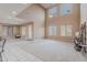 Spacious living room with soaring ceilings, large windows, and access to an outdoor patio with neutral carpet at 3458 E Ivanhoe St, Gilbert, AZ 85295