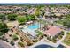 Aerial view of a community pool with cabanas surrounded by landscaping and lush neighborhood at 3458 E Ivanhoe St, Gilbert, AZ 85295