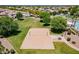 Aerial view of a sand volleyball court, lush green lawn, and community landscape at 3458 E Ivanhoe St, Gilbert, AZ 85295
