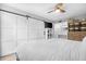 Stylish bedroom with sliding barn door, a ceiling fan, and neutral decor at 3500 N Hayden Rd # 2110, Scottsdale, AZ 85251