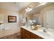 Well-lit bathroom with double sinks, a large mirror, and a separate bathtub at 3658 E Pony Track Ln, San Tan Valley, AZ 85140