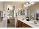 Bathroom featuring double sinks with oak cabinets leading into the main bedroom at 3658 E Pony Track Ln, San Tan Valley, AZ 85140