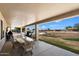 Covered patio featuring outdoor dining set, with views of a pool with a rock waterfall at 3658 E Pony Track Ln, San Tan Valley, AZ 85140