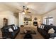 Comfortable living room with a fireplace, ceiling fan, neutral colors, and cozy seating perfect for relaxation at 3658 E Pony Track Ln, San Tan Valley, AZ 85140