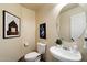 Powder room with a decorative mirror, artwork, and a sink at 3658 E Pony Track Ln, San Tan Valley, AZ 85140