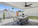 Covered back patio with a modern metal dining table and chairs, complemented by a ceiling fan and views of the yard at 4215 E Flower St, Phoenix, AZ 85018