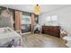 A bedroom features neutral paint, wood floors, play furniture, floral decals, and an oversized window at 4215 E Flower St, Phoenix, AZ 85018