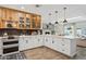 An open kitchen with white cabinets, stainless steel appliances, and views of the living room fireplace at 4215 E Flower St, Phoenix, AZ 85018