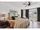 A bright main bedroom features wood floors, a ceiling fan, and glass doors to the back yard at 4215 E Flower St, Phoenix, AZ 85018
