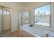 Bathroom featuring tub, shower, and a large window overlooking backyard at 4248 E Jason Dr, Phoenix, AZ 85050
