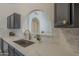 Kitchen sink with quartz countertops and backsplash plus an archway leading to other rooms at 4248 E Jason Dr, Phoenix, AZ 85050