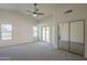 Bright main bedroom featuring carpet, a ceiling fan, slider to the backyard, and mirrored closet at 4248 E Jason Dr, Phoenix, AZ 85050