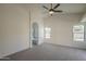 Carpeted main bedroom with vaulted ceiling, ceiling fan, and arched entrance to the bathroom at 4248 E Jason Dr, Phoenix, AZ 85050