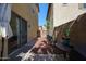 Narrow backyard featuring a stone pathway, potted plants, and views to the backyard gate at 451 S Hawes Rd # 53, Mesa, AZ 85208