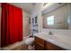 Bathroom with tile floor, wooden vanity, toilet, shower and red curtain at 451 S Hawes Rd # 53, Mesa, AZ 85208